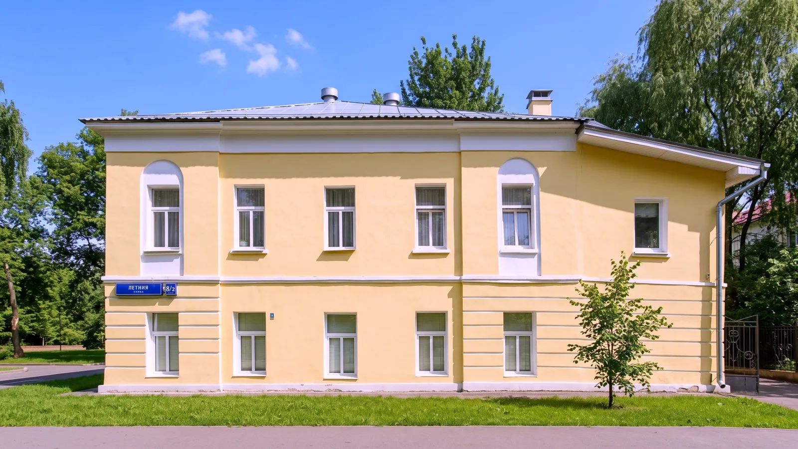 Двухэтажный жёлтый каменный дом на Летней улице, 8, стоящий отдельно на газоне